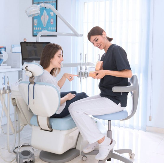Two women discussing bone grafting at a dental clinic